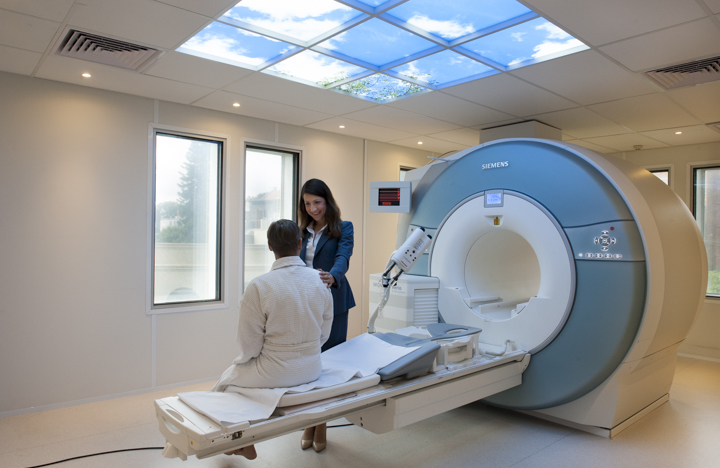 Patient being prepared for an MRI scan by a radiologist in a modern imaging suite